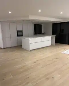 Cuisine contemporaine avec îlot central et sol effet bois clair